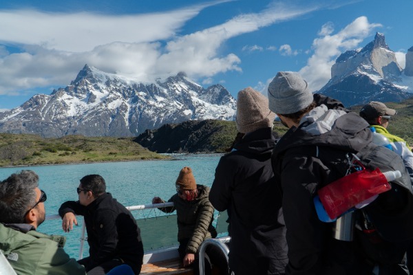 gruppo di persone sul catamarano che naviga sul lago Pehoe