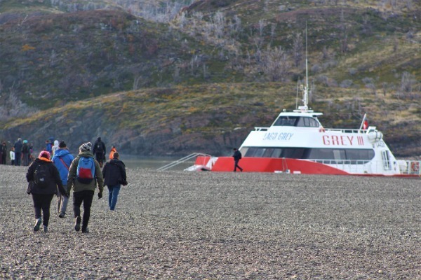 Spedizione Grigio III Escursionisti a piedi lungo Playa Grey per imbarcarsi sul catamarano Grey III a Torres del Paine