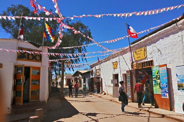 San Pedro de Atacama strada trafficata nel centro di San Pedro de Atacama e decorata con bandiere.