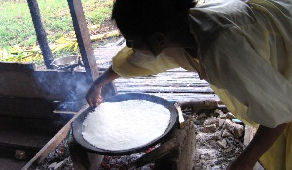 Donna che cucina la manioca