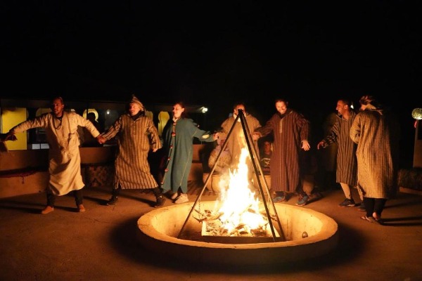 Serata berbera al glamping di Merzouga Viaggiatori attorno a un falò durante una serata all’insegna della musica berbera nel glamping di Merzouga