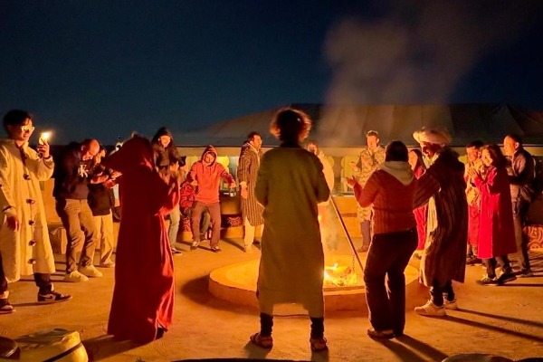 Serata berbera al glamping di Merzouga Viaggiatori attorno a un falò durante una serata all’insegna della musica berbera nel glamping di Merzouga
