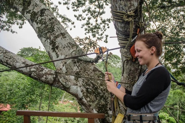 Traversata tirolese nella foresta amazzonica Viaggiatore che si diverte a fare zip-lining tra gli alberi nella giungla amazzonica di Puerto Maldonado.
