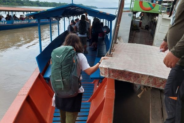 Giro in barca a Puerto Maldonado Viaggiatrice che sale su una barca nel porto di Puerto Maldonado diretta al lodge dell'Amazzonia.